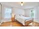 Comfortable bedroom with light wood floors, natural light, and neutral decor at 1516 Edgevale Rd, Durham, NC 27701