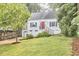 Charming home boasts a well-manicured lawn, bright red door, and attached garage at 1516 Edgevale Rd, Durham, NC 27701
