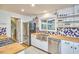 Well-lit kitchen with stainless steel appliances, butcher block counters and blue patterned tiling at 1516 Edgevale Rd, Durham, NC 27701