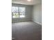 A bedroom featuring neutral walls, carpeting, and a bright window with views of the neighborhood at 1524 Chirping Bird Ct, Cary, NC 27519