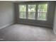 Bedroom with three large windows providing ample natural light and plush carpeting at 1524 Chirping Bird Ct, Cary, NC 27519