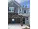 New construction home features a gray facade with stone accents and an attached two-car garage at 1524 Chirping Bird Ct, Cary, NC 27519