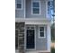 New construction home features a gray facade with white trim around the black front door and adjacent windows at 1524 Chirping Bird Ct, Cary, NC 27519
