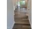 Hallway with stylish hardwood floors leading to a living room with fireplace and an exterior door at 1524 Chirping Bird Ct, Cary, NC 27519