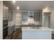 Spacious kitchen features gray cabinets, stainless steel appliances, white subway tile backsplash, and an island with sink at 1524 Chirping Bird Ct, Cary, NC 27519