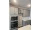 Kitchen features gray cabinets, stainless steel appliances including built-in microwave and oven, and white countertops at 1524 Chirping Bird Ct, Cary, NC 27519