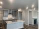 Open-concept kitchen with gray cabinets, quartz countertops, a range hood, and a view of the fireplace at 1524 Chirping Bird Ct, Cary, NC 27519