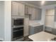 Gourmet kitchen featuring stainless steel appliances, gray cabinets, subway tile backsplash, and quartz counters at 1524 Chirping Bird Ct, Cary, NC 27519