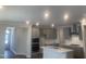 Open kitchen features gray cabinets, stainless steel appliances, and a large island with sink and quartz countertops at 1524 Chirping Bird Ct, Cary, NC 27519