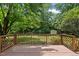 View of back deck with decorative wood railing overlooking a spacious, fenced yard at 1601 Redmond Dr, Durham, NC 27712