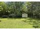 The backyard includes a storage shed, lush grass, and mature trees at 1601 Redmond Dr, Durham, NC 27712
