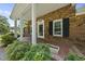 Close up of front porch showing brick detail, white columns, and manicured greenery at 1601 Redmond Dr, Durham, NC 27712