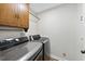 Efficient laundry room with modern washer and dryer units and overhead cabinet storage at 1601 Redmond Dr, Durham, NC 27712