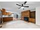 Bright living room features a brick fireplace, ceiling fan, built-in shelves, and open access to the kitchen at 1601 Redmond Dr, Durham, NC 27712