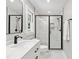 The updated bathroom includes modern fixtures, glass shower, and bright white tile and cabinets at 1609 Falls Ct, Raleigh, NC 27615