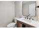 Stylish half-bath features modern fixtures, a wood vanity, and a sleek mirror at 1609 Falls Ct, Raleigh, NC 27615