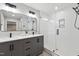 Modern bathroom featuring a double sink vanity and a glass-enclosed shower with white subway tile at 1609 Falls Ct, Raleigh, NC 27615