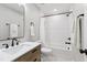 Updated bathroom with a wood vanity, white counters, and a subway tile shower over tub at 1609 Falls Ct, Raleigh, NC 27615