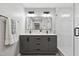 Elegant bathroom with double sinks, modern mirrors, stylish lighting, and a glass-enclosed shower at 1609 Falls Ct, Raleigh, NC 27615