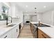 Bright kitchen with white cabinets, quartz countertops, stainless steel appliances, and hardwood floors at 1609 Falls Ct, Raleigh, NC 27615