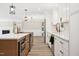 Modern kitchen features white cabinets, stainless appliances, and a large island with pendant lighting at 1609 Falls Ct, Raleigh, NC 27615