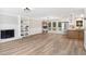 Spacious living room features a brick fireplace, modern lighting, an open floorplan and eat-in kitchen at 1609 Falls Ct, Raleigh, NC 27615