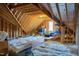 Spacious unfinished attic with exposed rafters, insulation, and natural light from a window at 1918 Morning Fog Dr, Fuquay Varina, NC 27526