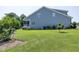Spacious backyard with lush grass, garden beds, and view of screened porch of home at 1918 Morning Fog Dr, Fuquay Varina, NC 27526
