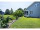 Inviting backyard featuring a lush green lawn, garden beds, and a view of the house with a screened-in porch at 1918 Morning Fog Dr, Fuquay Varina, NC 27526