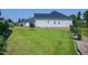 Lush backyard with well-kept lawn, garden beds, and view of the side of the house and driveway at 1918 Morning Fog Dr, Fuquay Varina, NC 27526