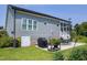 Expansive backyard featuring a lush green lawn, patio area, and the exterior of the home with gray siding at 1918 Morning Fog Dr, Fuquay Varina, NC 27526