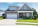 Charming home featuring a stone facade, white garage door and manicured front lawn at 1918 Morning Fog Dr, Fuquay Varina, NC 27526