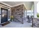 Covered front porch showcasing stone accents and a black front door at 1918 Morning Fog Dr, Fuquay Varina, NC 27526
