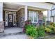 Inviting front porch with stone accents, rocking chairs, and lush landscaping at 1918 Morning Fog Dr, Fuquay Varina, NC 27526