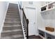 Carpeted stairway with dark wood railing and a view of the storage area and entrance at 1918 Morning Fog Dr, Fuquay Varina, NC 27526