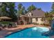 Exterior view of home featuring backyard pool, brick paver patio, screened porch, and lush landscaping at 2012 Silverleaf Dr, Youngsville, NC 27596