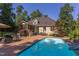 Exterior view of home featuring backyard pool, brick paver patio, screened porch, and lush landscaping at 2012 Silverleaf Dr, Youngsville, NC 27596