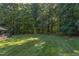 Green backyard featuring a well-manicured lawn and mature trees, creating a private outdoor space at 2012 Silverleaf Dr, Youngsville, NC 27596