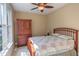 Bright bedroom with hardwood furniture, ceiling fan, and large window offering outdoor views at 2012 Silverleaf Dr, Youngsville, NC 27596
