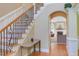 Entryway with hardwood floors, staircase with iron balusters, and view into the living room at 2012 Silverleaf Dr, Youngsville, NC 27596