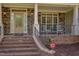 Charming front porch with stone accents, rocking chairs, and decorative front door at 2012 Silverleaf Dr, Youngsville, NC 27596