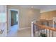 Upstairs hallway featuring wrought iron spindles, with an open doorway into another room at 2012 Silverleaf Dr, Youngsville, NC 27596