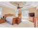 Spacious main bedroom with a wooden bed frame, tray ceiling, and large windows at 2012 Silverleaf Dr, Youngsville, NC 27596