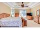 Bright main bedroom with natural light, wooden furniture, and elegant tray ceiling at 2012 Silverleaf Dr, Youngsville, NC 27596