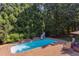 Backyard pool with slide and brick paver patio, surrounded by mature landscaping and lush green trees at 2012 Silverleaf Dr, Youngsville, NC 27596