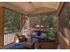 Relaxing screened porch featuring wicker furniture, string lights, and scenic backyard views of the pool and lush landscaping at 2012 Silverleaf Dr, Youngsville, NC 27596