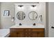 Bathroom with double sinks, modern lighting, and shiplap accent wall at 204 Edgepine Dr, Holly Springs, NC 27540