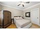 Comfortable bedroom with hardwood floors, wicker cabinet, and neutral color palette at 204 Edgepine Dr, Holly Springs, NC 27540