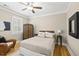 Bedroom with hardwood floors and a decorative wicker accent chair and cabinet at 204 Edgepine Dr, Holly Springs, NC 27540