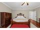 Bedroom with hardwood floors and a large bed with a red bench at the foot at 204 Edgepine Dr, Holly Springs, NC 27540